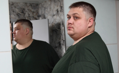 Молодой мужчина смотрит в зеркало