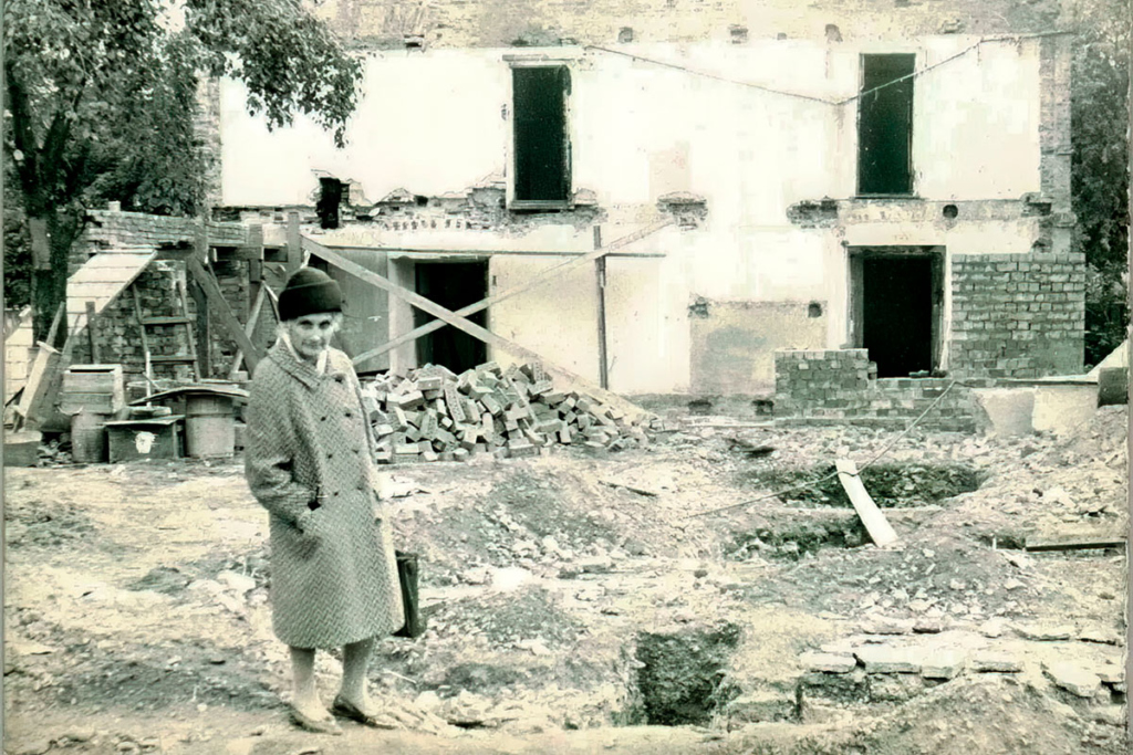 Любовь Митрофановна Шуляк на фоне восстанавливаемого дома причта Спасо-Преображенской церкви (Спаса на Ильине),1848 года