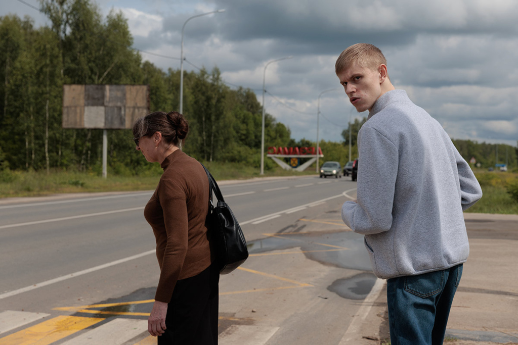 Юноша идет за мамой через дорогу