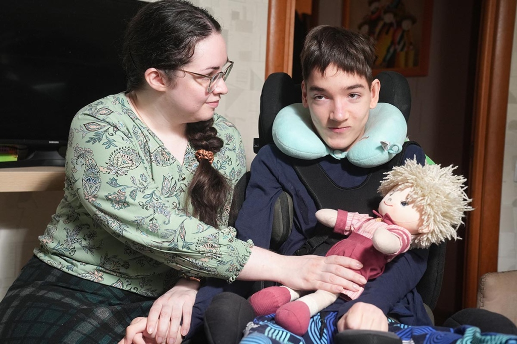 Мальчик в инвалидной коляске с мамой и игрушкой