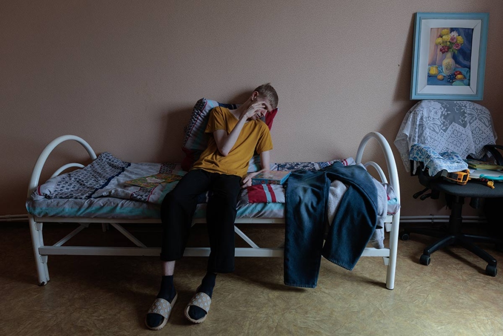 Юноша сидит на кровати