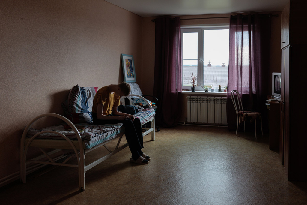 Юноша сидит на кровати