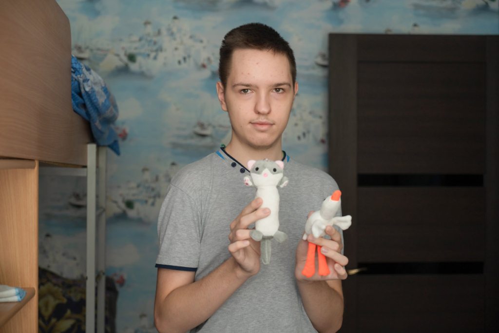 юноша показывает игрушки