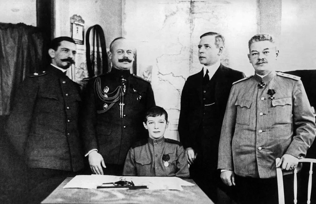 Цесаревич Алексей Николаевич (в центре), его воспитатель, наставник, преподаватель французского языка Петр Андреевич Жильяр (крайний слева), дворцовый комендант, генерал-майор Свиты Владимир Николаевич Воейков (второй слева), учитель английского языка Сидней Гиббс (второй справа) и учитель русской словесности Петр Васильевич Петров (крайний справа ) в Ставке Верховного главнокомандующего Российской армией во время Первой мировой войны. 1916 год. Российская империя. Могилев. Репродукция ТАСС