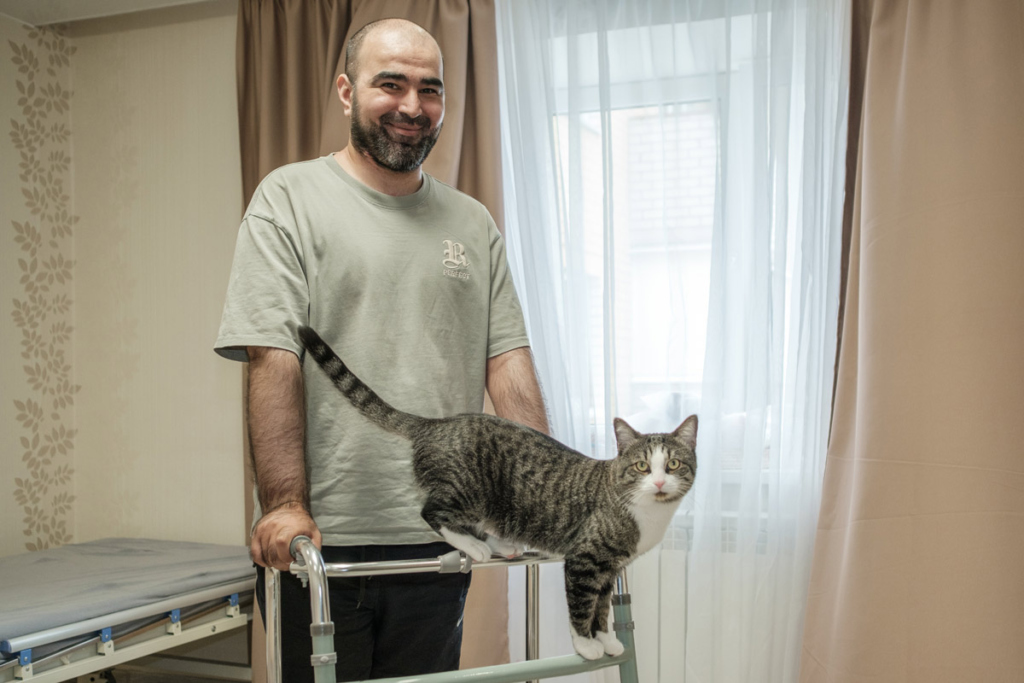 Мужчина с ходунками и кошкой